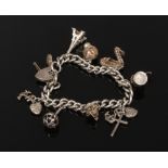 A silver charm bracelet on curb chain and with heart shaped clasp, 54 grams.