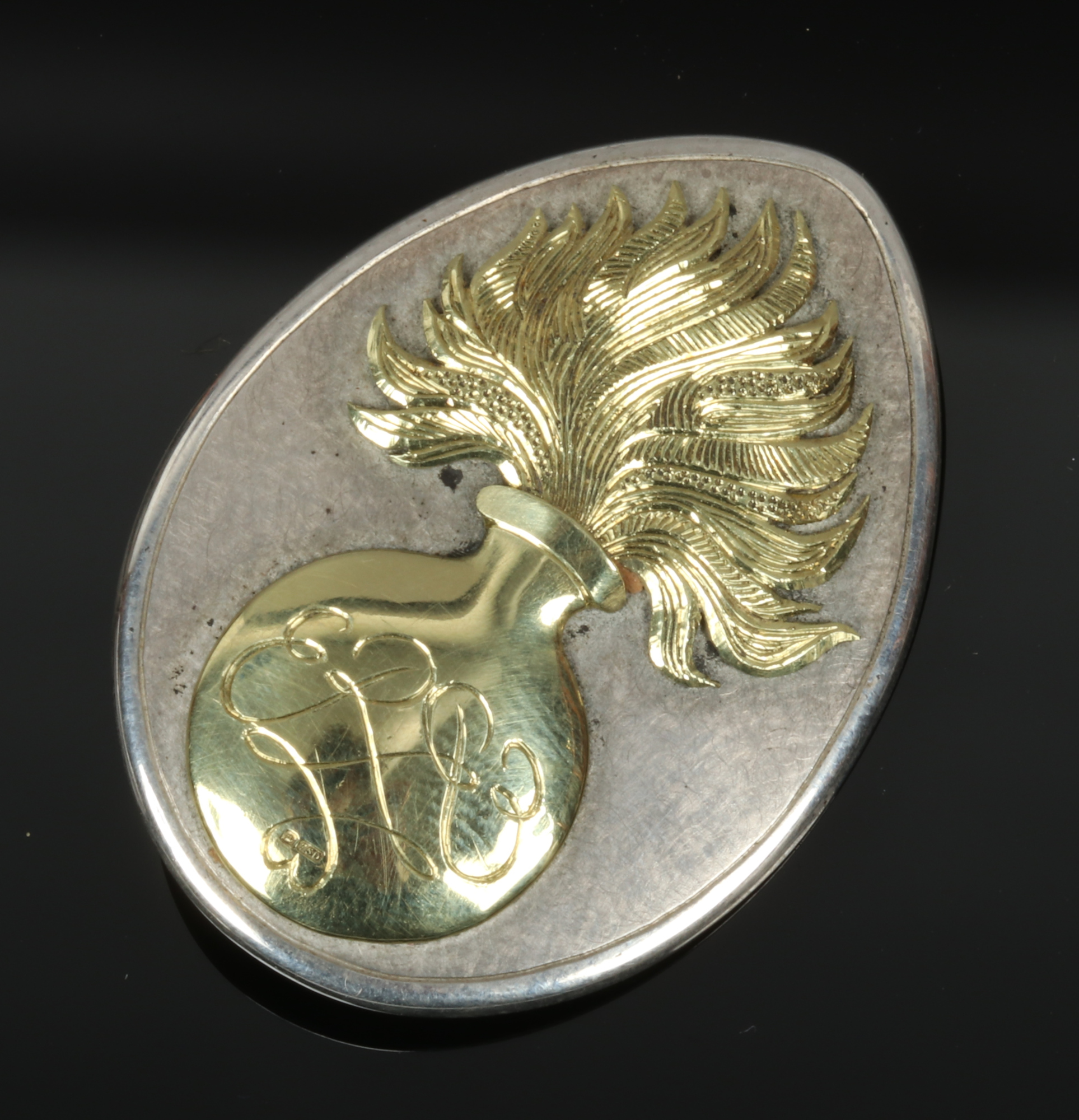 A silver and 18 carat gold mounted Grenadier Guards sweetheart brooch of tear form. Set with the