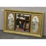 An Edwardian bevel edge mirror flanked by portrait prints of ladies in oval mounts.