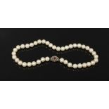 A pearl necklace with silver and coloured paste stone clasp.