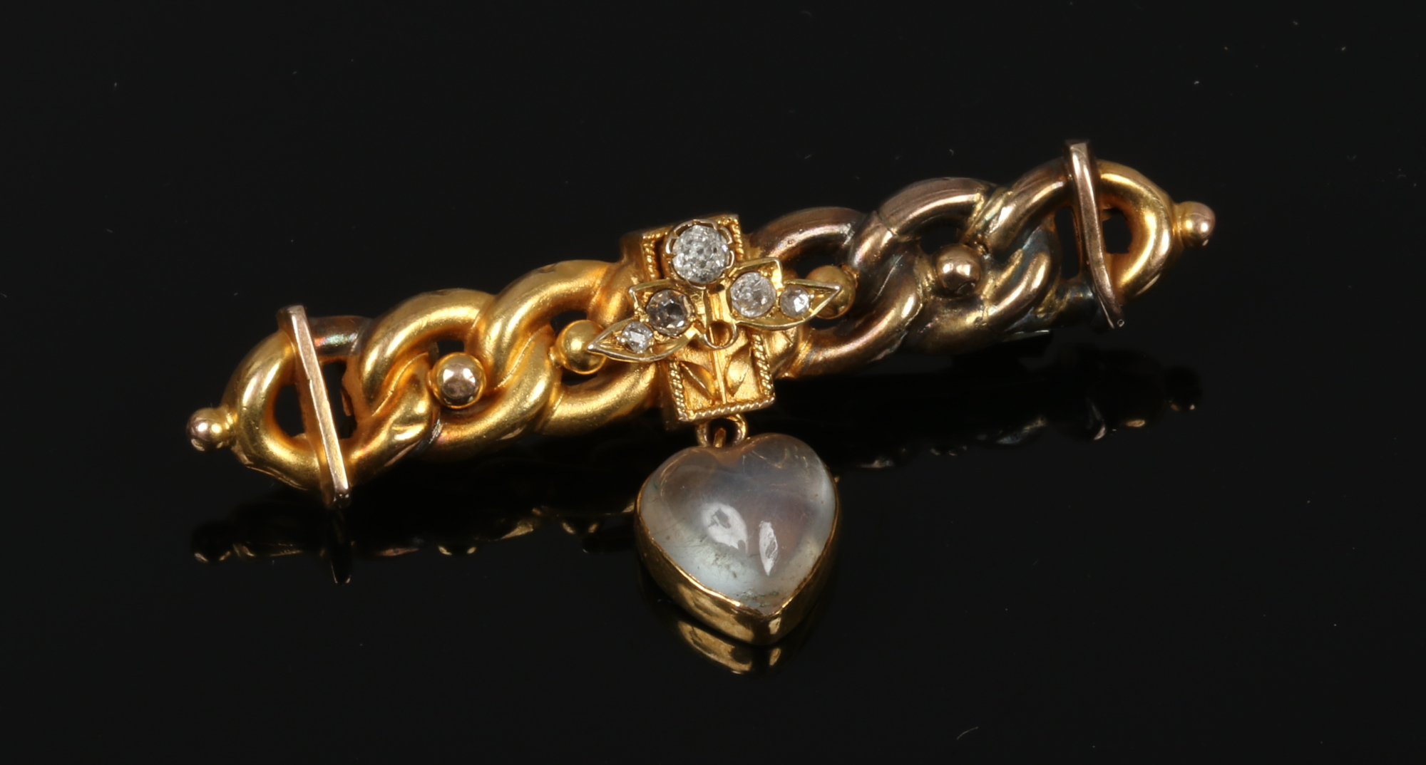 An 18ct gold bar brooch set with diamonds and heart shaped moonstone pendant.
