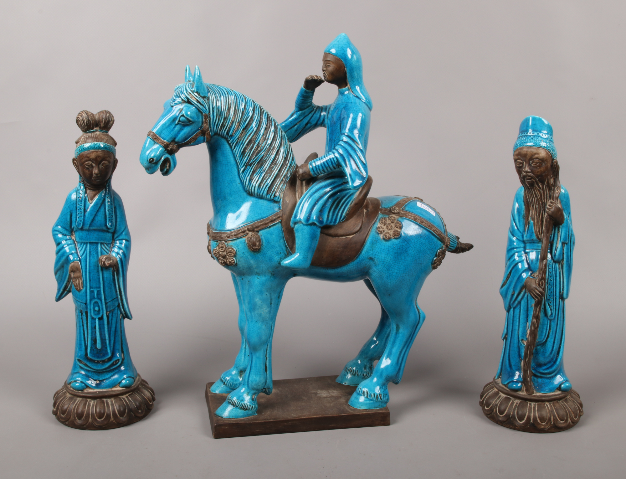 A pair of Chinese blue glazed earthenware models of immortals, along with a Tang style horse and