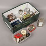 A box of collectables to include police whistles, costume jewellery domino set etc.