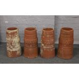 Four terracotta chimney pots height 59cm.