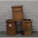 Three terracotta chimney pots.