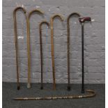 A bundle of seven walking sticks to include folding example.