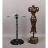 A decorative scrap metal occasional table with toughened glass top, along with a model in the female