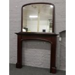 A dark stained mahogany fire surround and over mantle mirror.
