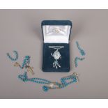 A silver native American themed dream catcher pendant on chain and a string of turquoise effect