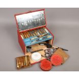 A vintage red theatre make up case and contents.