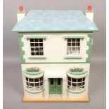 A white and green painted dolls house with contents of dolls furniture to include treadle sewing