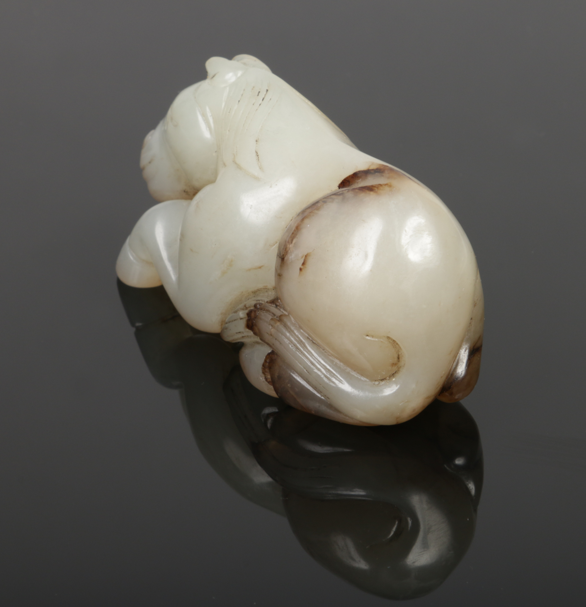 A Chinese carved pale celadon jade recumbent horse with dark brown suffusions, 7.75cm.Condition - Image 3 of 4