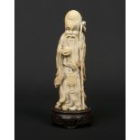 A 19th century Chinese carved ivory figure of a sage dressed in flowing robes carved with shou