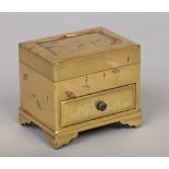 A Japanese Meiji period miniature gold lacquered table cabinet. Decorated with cranes, with fitted