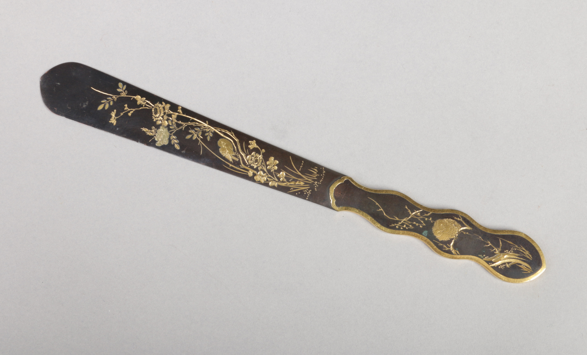 A Japanese bronze paper knife. Engraved with birds and flowers and having gilt embellishments, 22.