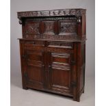 A William and Mary period oak court cupboard. The frieze is carved with trailing vines, inscribed R.