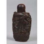 A 19th century Chinese carved horn snuff bottle. Surmounted by a pair of mythical beasts and with