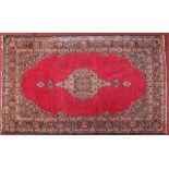 An early 20th century Persian red ground wool rug with central medallion, 217cm x 320cm.