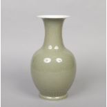 A Chinese celadon baluster shaped vase. Carved with stiff leaves to the colar and lotus scrolls to