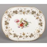 A Rockingham serving dish with C-scroll moulding. Decorated with a border of vines in gilt and