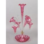 A cranberry glass three flute epergne with three baskets supported on clear glass scrolls, 59.5cm.