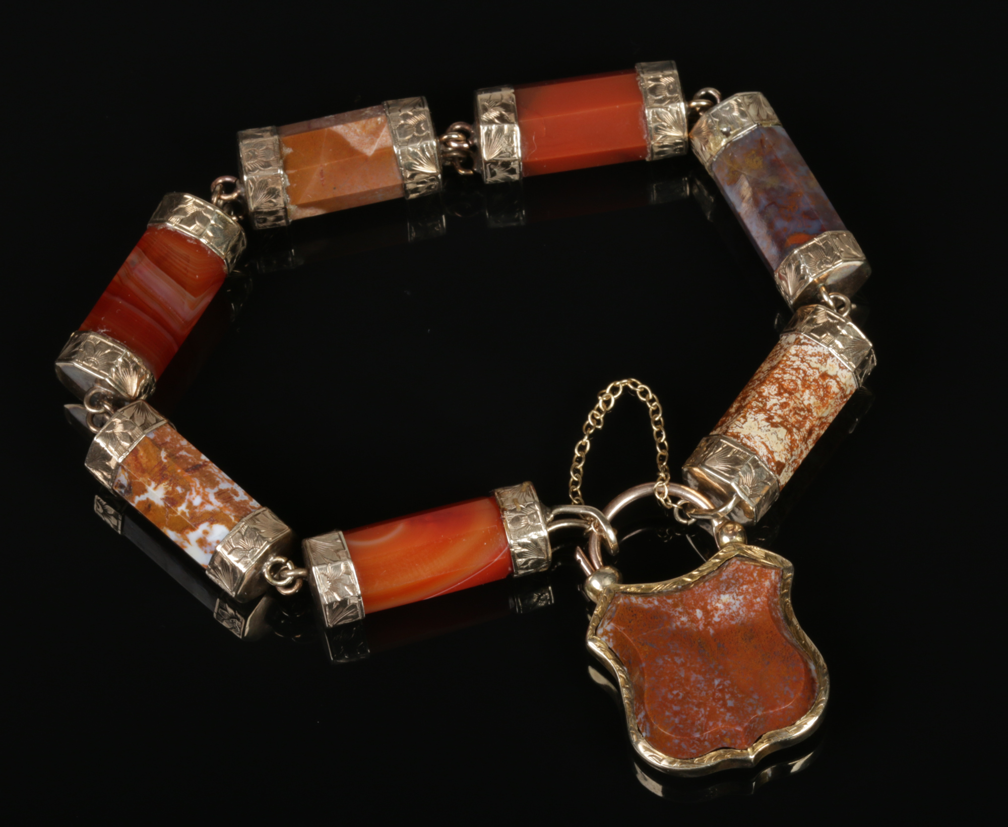 A Victorian pinchbeck mounted agate bracelet with shield shaped mourning locket containing a plait