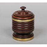 An early 19th century turned treen pedestal tobacco jar and cover of wassail bowl form with brass
