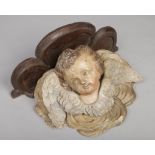 An 18th century Flemish polychrome carved corbel bracket. Modelled in the Baroque style as a putto
