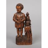 An early 19th century carved treen figural sewing companion. Formed as a young boy gathering