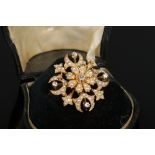 A Victorian cased 15 carat gold starburst brooch. Set with seed pearls and five old European cut