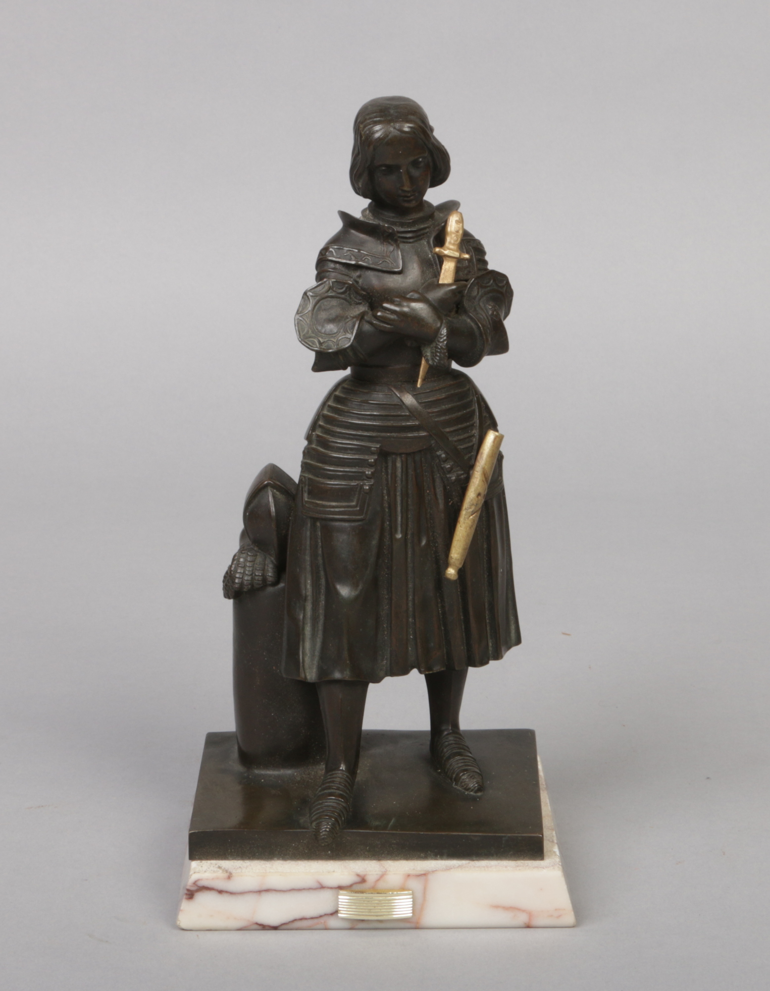 An early 20th century French patinated bronze figure of Joan of Arc. Raised on an associated