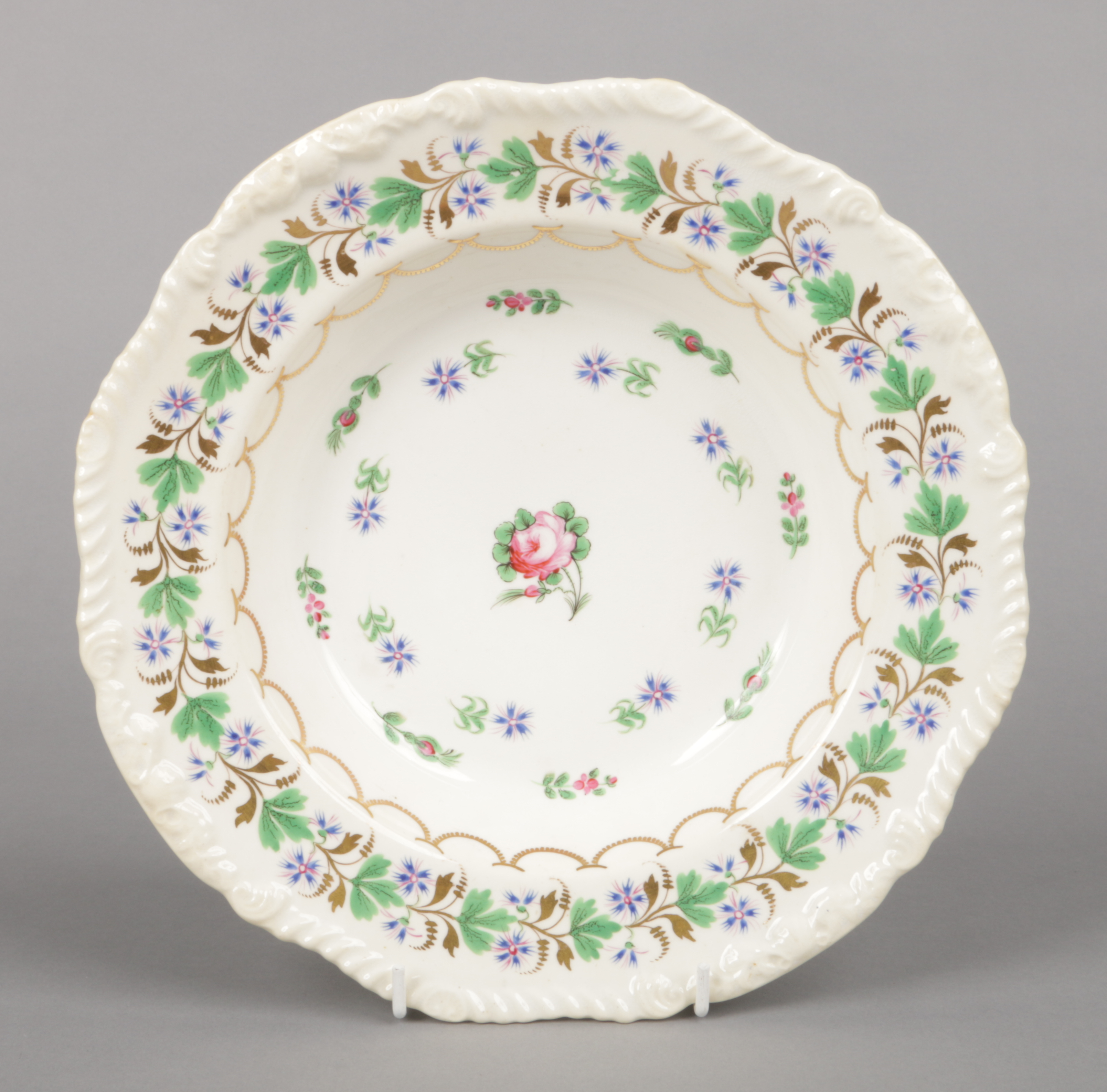 A Rockingham soup plate with gadroon, acanthus leaf and shell moulding. Decorated in gilt and enamel