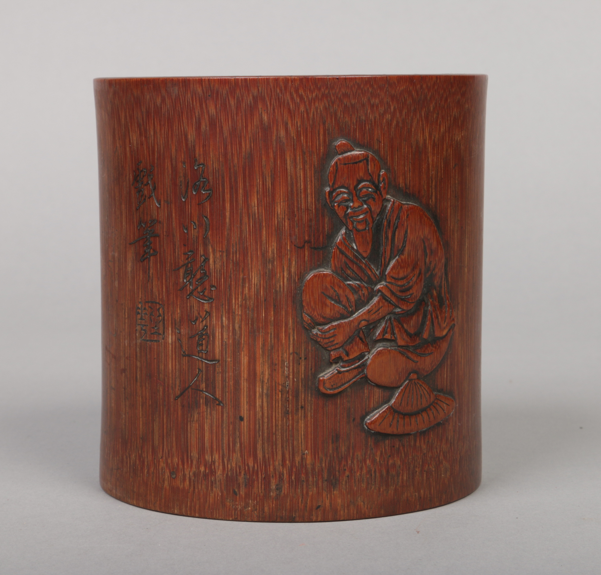 A Chinese bamboo bitong. Carved in light relief with a figure and with incised character