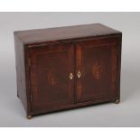 A Georgian mahogany table cabinet, crossbanded, with strung inlay, patera and raised on brass ball