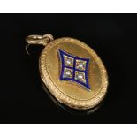 A small Victorian yellow metal locket of ovoid form. Chased with scrolls and shells and with a
