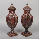 A pair of Sarreguemines majolica lidded urns. Reeded in form and with mottled treacle glaze,