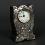 An Edwardian silver mounted desk clock decorated with a pair of Dutch children in a landscape.
