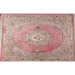 A large mid 20th century Chinese pink ground wool rug. With a centre medallion under a floral