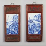 Two Chinese blue and white rectangular plaques in carved wooden frames with bronze hanging loops.