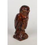 A large treacle glazed pottery model of an owl perched on a naturalistic base, 55cm high.Condition