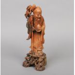 A Chinese well carved soapstone figure of Shou Lao. The bearded figure holding a staff and a peach