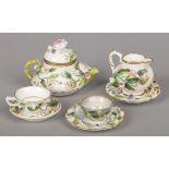 An assembled Rockingham miniature part teaset. Each piece gilded and decorated with applied