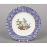 An 18th century Sevres plate. With blue ground oeil de perdrix border framing a landscape vignette