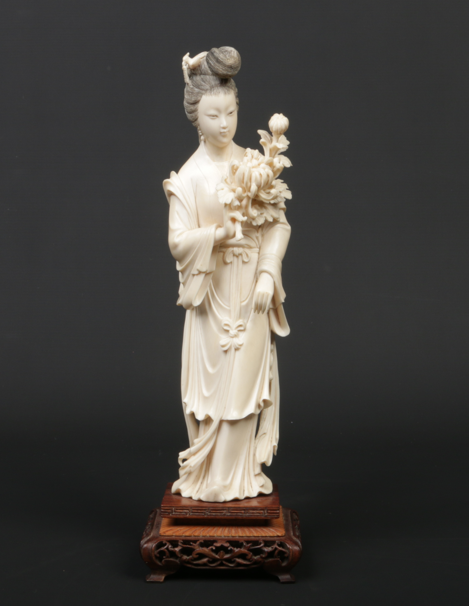 A 19th century Chinese carved ivory figure of Guanyin. Wearing long flowing robes, holding a