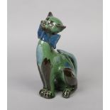 A C. H. Brannam Barum pottery novelty model of a seated cat wearing a bow tie and decorated in green