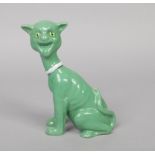 A Mosanic pottery novelty model of a cat. In seated pose, green glazed and with glass eyes, 20.5cm.