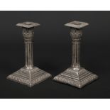 A pair of George V silver dwarf candlesticks. With acanthus shaped sconces, raised on cluster