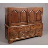 A Georgian oak Lancashire chest converted to a press cupboard. With panelled top raised on a six