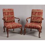 A pair of Georgian style upholstered mahogany open armchairs raised on carved cabriole supports,