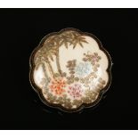 A Japanese Meiji period Satsuma brooch of lobed form. Painted with flowers and bamboo shoots under a